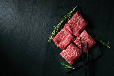 Siyah arka planda Yakiniku için dilimlenmiş wagyu mermer eti, kaliteli Japon eti, üst görünüm ve kopyalama alanı