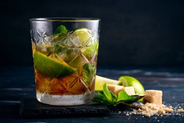 Siyah rom, limon ve naneli kokteyl, Brezilya Caipirinha alkollü koyu ahşap içki.