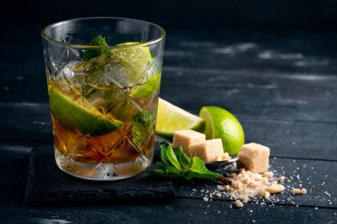 Siyah rom, limon ve naneli kokteyl, Brezilya Caipirinha alkollü koyu ahşap içki.