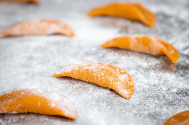 Metal masa üzerinde un bulunan İtalyan mantısı yapma süreci. Seçici odak.