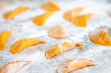 Metal masa üzerinde un bulunan İtalyan mantısı yapma süreci. Seçici odak.