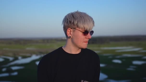 Portret van een blonde mannen op een achtergrond van een prachtig landschap bij zonsondergang — Stockvideo