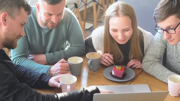 Gelukkig groep vrienden of collega's koffie drinken, lachen en samen gebruiken van de computer in een klein café of wijnbar — Stockvideo