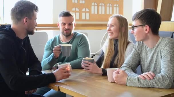 Gelukkig groep vrienden of collega's koffie drinken, lachen en samen gebruiken van de computer in een klein café of wijnbar — Stockvideo