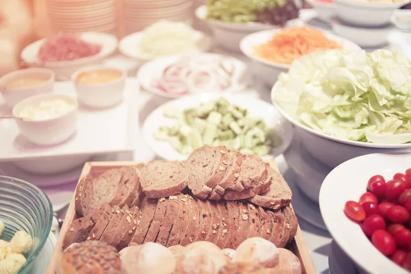 Salad buffet, Salad bar with bread various fresh vegetables and other foods.