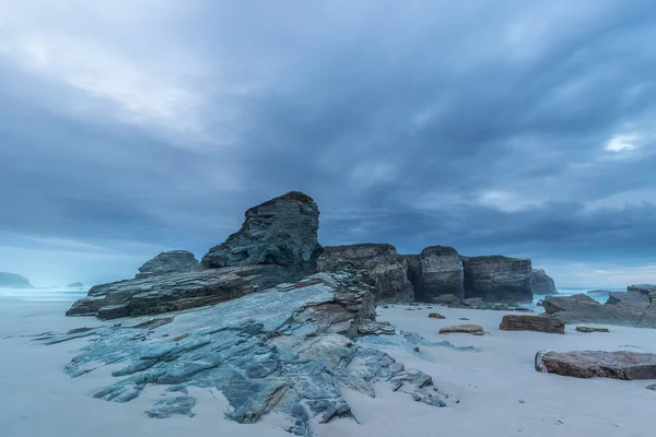 Fırtına günbatımı üzerinde plaj, Las orada nerede büyük bir sihirli-seyir Islas, çeşitli renk bulutlar yoğunlaşmaktadır monolith