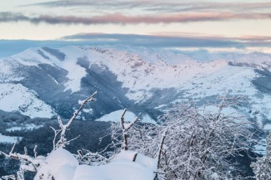 bir kış günü kar, bulutlar ve dağ ile zıt ilk güneş ışınlarının eşsiz renklerin fotoğraf için erken kar, dolu Ubina, Leon, arasındaki Asturias dağlarında gündoğumu ...