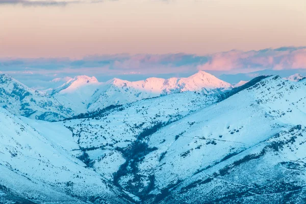 bir kış günü kar, bulutlar ve dağ ile zıt ilk güneş ışınlarının eşsiz renklerin fotoğraf için erken kar, dolu Ubina, Leon, arasındaki Asturias dağlarında gündoğumu ...