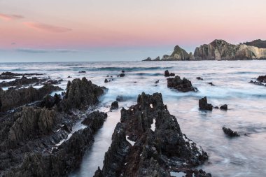 Gueirua beach, rahatsız edici bir manzara okyanus tarafından ortaya keskin kayalar ile etkileyici bir güzellik şafakta alacakaranlıkta ve yıldızlı gece başka bir dünyadan gelen gibi davranıyor