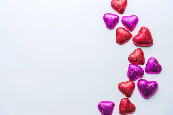 Chocolates Vermelhos Cor Rosa Envoltos Forma Coração Espalhados Pelo Lado — Fotografia de Stock