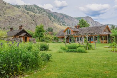 Keremeos, British Columbia/Canada - June 3, 2017: gardens, historic cellar, and restaurant building at The Grist Mill and Gardens Keremeos, an important heritage site dating to 1877. clipart