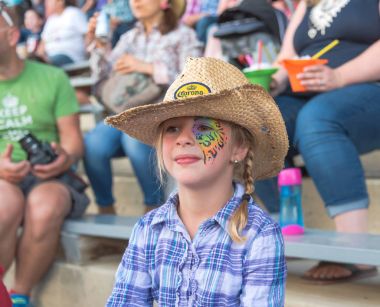 Williams Lake, British Columbia/Canada - July 1, 2016: young girl in face paint and cowboy hat watches the 90th Williams Lake Stampede, one of the largest stampedes in North America clipart