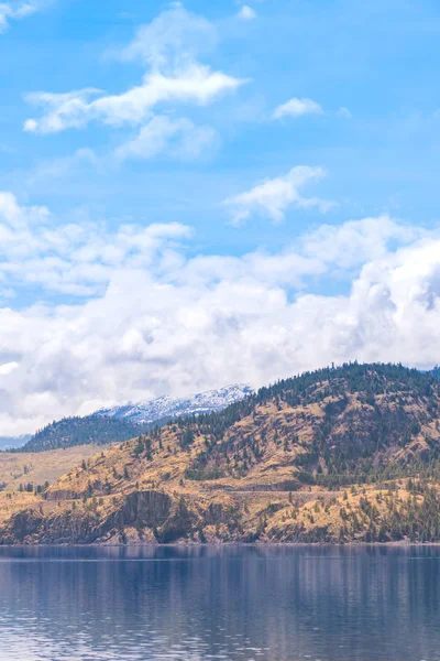 Paesaggio Lago Colline Erbose Montagne Innevate Cielo Azzurro Nuvole Nelle — Foto Stock