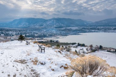 Winter view of Penticton covered in snow with view of Okanagan Lake and mountains clipart