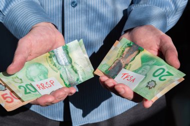 Rrsp ve Tfsa yatırımları için Kanada parası tutan adamın yakın çekimi.