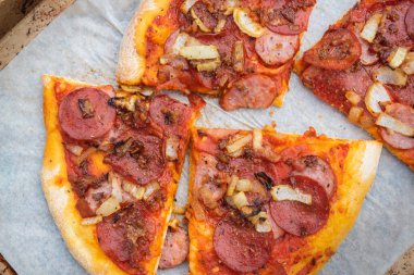 Ev yapımı ince hamurlu peynirli sosisli ve karamelli soğanlı pizza.