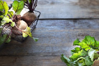 Tahta bir sepetin üzerinde yaprakları olan taze organik kırmızı pancarlar. Doğal organik sebzeler. Sonbahar hasadı. Taşralı. Boşluğu kopyala