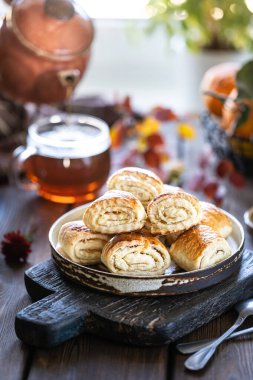 Tahta bir masada bir fincan çay ve mandalina ile oryantal tatlı gata. Seçici odak