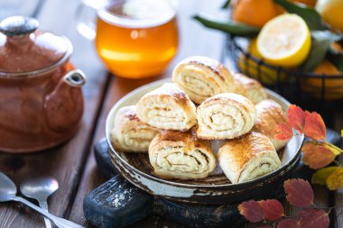 Tahta bir masada bir fincan çay ve mandalina ile oryantal tatlı gata. Seçici odak