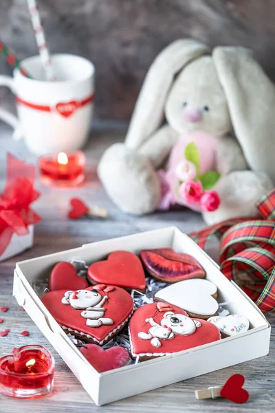 Печенье или пряничное печенье в подарочной коробке с красной лентой на деревянном столе. День святого Валентина. — стоковое фото