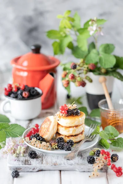 Hausgemachte Pfannkuchen mit Beeren, den Brombeeren, dem Honig auf dem Teller, einem Zweig eines Brombeerweckers auf weißem Holzgrund — Stockfoto