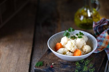 Koyu ahşap bir masada cam bir kavanozda havuçlu karnabahar turşusu. Mayalanmış yiyecek. Boşluğu kopyala