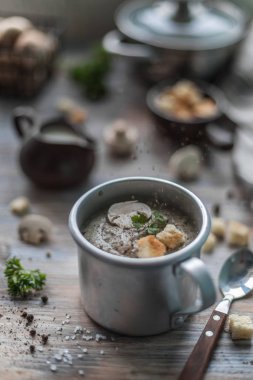 Metal bardakta buharı olan şampiyon mantar kremalı çorba.