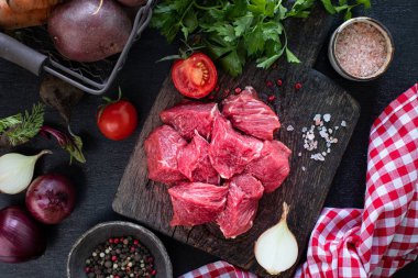 Çiğ biftek filetosu ızgara için hazır. Tahta kesme tahtasındaki dana filetosu, kiraz domatesleri, acı biber ve bitkilerle birlikte. Çorba ya da borç için malzemeler. kopyalama alanı. en üstteki görünüm.