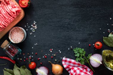 Çiğ biftek filetosu ızgara için hazır. Vişne domatesli, acı biberli ve otlu ahşap kesim tahtasındaki dana filetosu ve kıyma. Çorba ya da borç için malzemeler. kopyalama alanı. en üstteki görünüm.