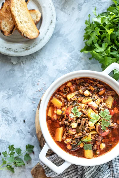 Dicke Hackfleischsuppe mit Tomaten, Bohnen, Kichererbsen und Gemüse. Gesundes Abendessen. Blick von oben. Kopierraum. Ansicht von oben — Stockfoto