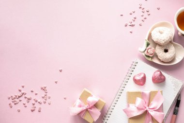 Hediye kutusu ya da hediye kutusu ve pembe masa manzaralı çiçekler. Düz yatıyordu. Doğum günü, düğün, sevgililer günü, 8 Mart konsepti. Boşluğu kopyala