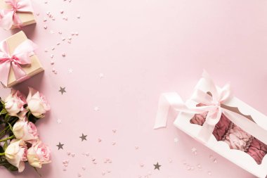 Hediye kutusu ya da hediye kutusu ve pembe masa manzaralı çiçekler. Düz yatıyordu. Doğum günü, düğün, sevgililer günü, 8 Mart konsepti. Boşluğu kopyala