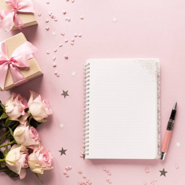 Hediye kutusu ya da hediye kutusu ve pembe masa manzaralı çiçekler. Düz yatıyordu. Doğum günü, düğün, sevgililer günü, 8 Mart konsepti. Boşluğu kopyala