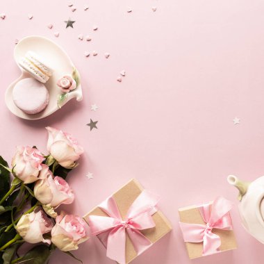 Hediye kutusu ya da hediye kutusu ve pembe masa manzaralı çiçekler. Düz yatıyordu. Doğum günü, düğün, sevgililer günü, 8 Mart konsepti. Boşluğu kopyala