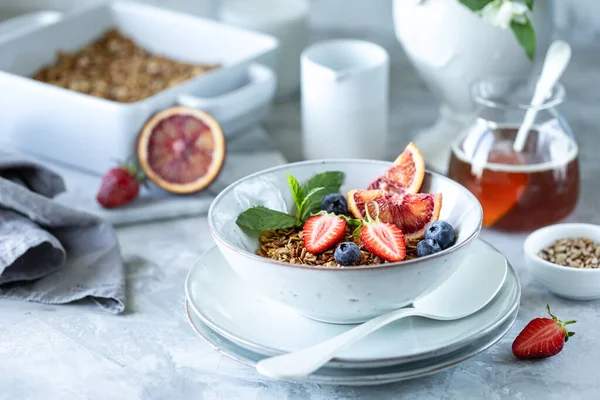 Здоровый завтрак с мюсли, йогуртом, фруктами, ягодами на белой тарелке . — стоковое фото
