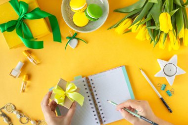 Şenlikli kompozisyon: hediyeli kutular, kurdeleler, çiçekler, mücevher ve kağıt defter, üst görünüm