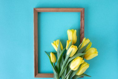 Güzel çiçek aranjmanı. Sarı çiçek laleleri, boş çerçeve mavi arkaplandaki yazı için. Düğün için. Sevgililer Günü 'nde. Anneler Günü. Düz yatış, üst görünüm