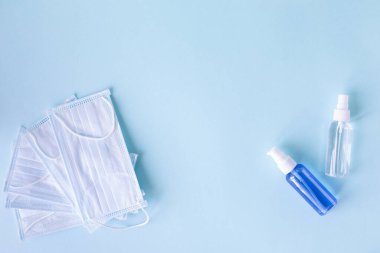 Mavi arka planda tıbbi konsept. Virüse karşı korunma araçları: tıbbi maske, antiseptikler, el hijyen ürünleri, dezenfektanlar.