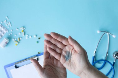 Mavi arka planda tıbbi konsept. Stetoskop, haplar, tablet, not defteri, kağıt, kalem.