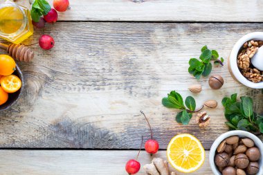 Bağışıklık için sağlıklı ürünler ahşap arka planda yükseltiliyor ve üst görünümü kopyalıyor. Limon, fındık, kızıldan bağışıklık sistemine.