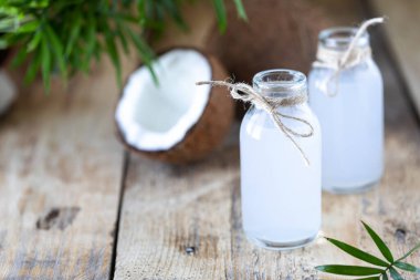 Masadaki cam şişede taze hindistan cevizi suyu. Vejetaryen içeceği