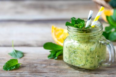 Ispanak, portakal, elma ve nane karışımlı cam kavanozda ev yapımı yeşil smoothie. Detoks, diyet, sağlıklı, vejetaryen gıda konsepti