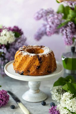 Hafif arka planda böğürtlen, buket ve leylaklı ev yapımı kek..