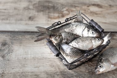 Tahta bir masadaki kasede çiğ nehir balığı.