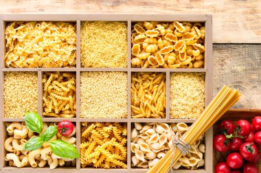 Tahta kutuda pişirilmemiş farklı İtalyan makarnaları, tam buğday makarnası, makarna, spagetti, erişte, tagliatelle. Üst görünüm.