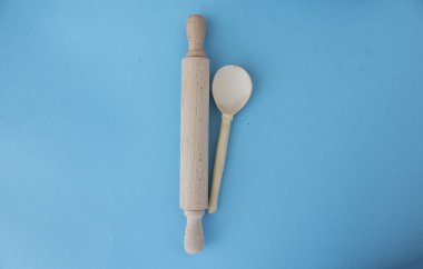 Beyaz ahşap kaşık ve mavi zemin üzerinde merdane