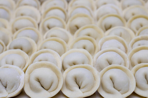 Многие пельмени лежат вместе, сделанные из мяса и теста
