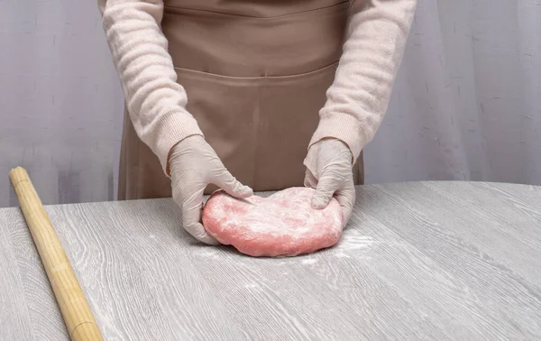 Kleurdeeg bereiden voor pelmeni, ravioli. Mama 's handen in handschoenen — Stockfoto