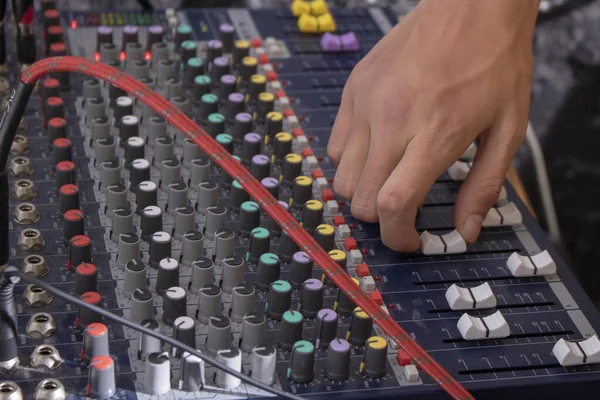 DJ hand on a mixer, operating the leader