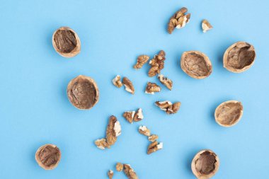 Mavi arka planda ceviz ve kabuk yarıları. Yatay